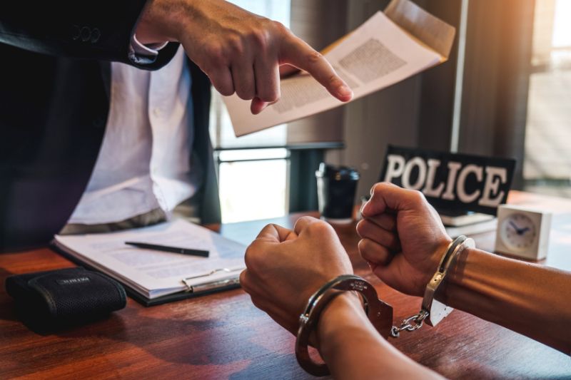 Persona esposada siendo acusada en un proceso penal con la presencia de un abogado