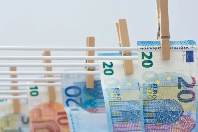 Billetes de euro colgados en un tendedero, representando el concepto de blanqueo de capitales.