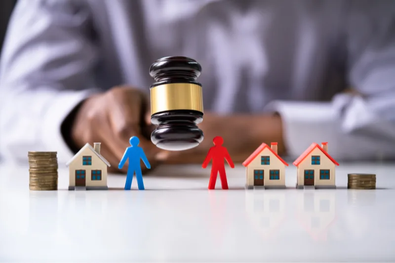 Juez dictando sentencia sobre el reparto de bienes en un divorcio contencioso.