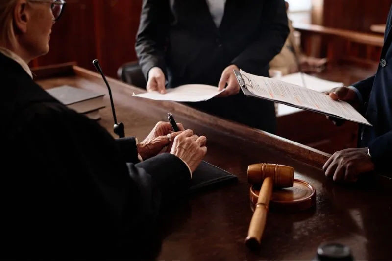Juez recibiendo documentos en un juicio por denuncia falsa en España. Denuncia falsa historial penal