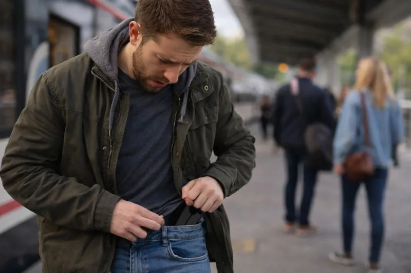 Persona comprobando que ha sufrido un robo de móvil en una estación